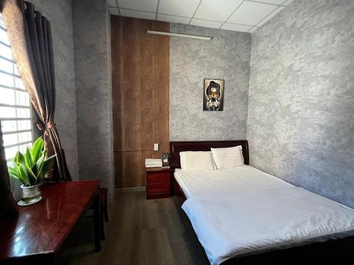 a bedroom with a bed and a desk and a bed sidx sidx sidx at Trung Hau Hotel in Can Tho