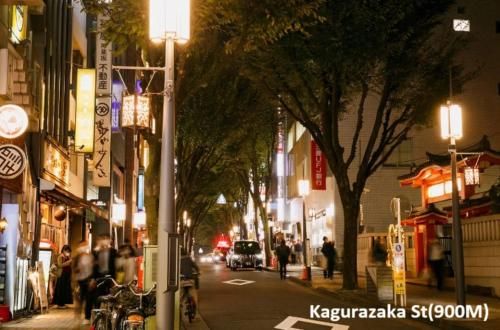a city street at night with people walking down the street at 江戸川橋レジデンス EDOGAWABASHI RESIDENCE in Tokyo