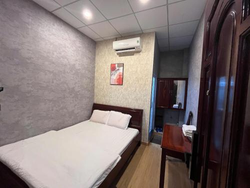 a small bedroom with a bed and a desk at Trung Hau Hotel in Can Tho
