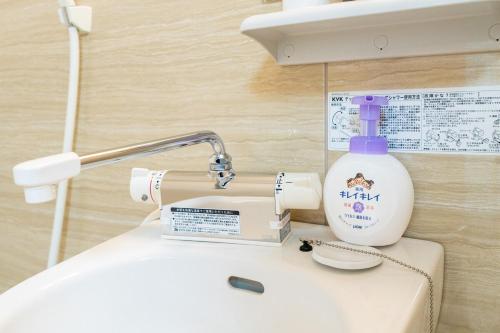 eine Flasche Waschmittel auf einem Waschbecken in der Unterkunft Cozy condo for 2 PPL near Teradacho Sta 4 min walk cecilia301 in Osaka
