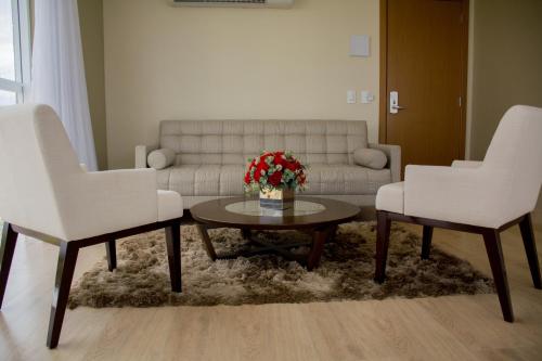 a living room with two white chairs and a coffee table at Select Hotel in Palmas