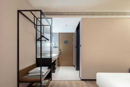 a room with a glass staircase leading to a bathroom at Atour Hotel Nantong Development Zone Aeon Mall in Nantong