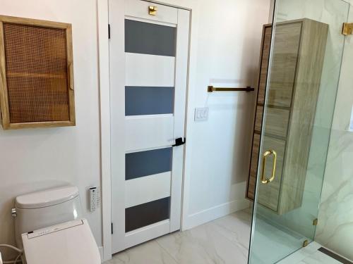 a bathroom with a toilet and a glass shower door at Mountain View Poolside Retreat in Agoura Hills