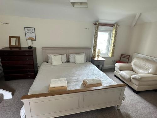 a bedroom with a large bed and a couch at 21 Trinity Avenue in Llandudno