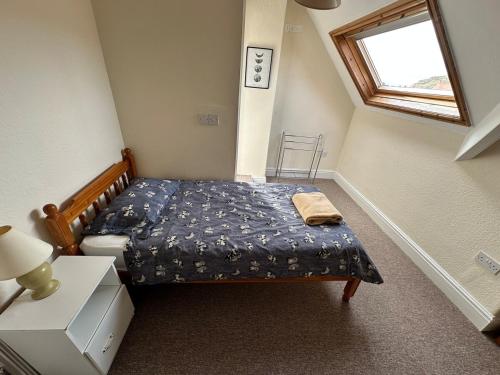 a small bedroom with a bed and a window at 21 Trinity Avenue in Llandudno
