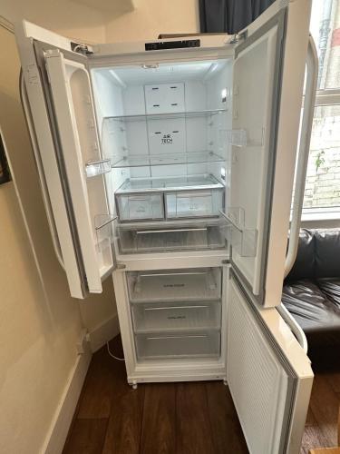 an empty refrigerator with its door open in a room at 21 Trinity Avenue in Llandudno
