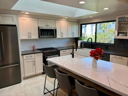 a kitchen with a large island with a white counter top at Mountain View Poolside Retreat in Agoura Hills