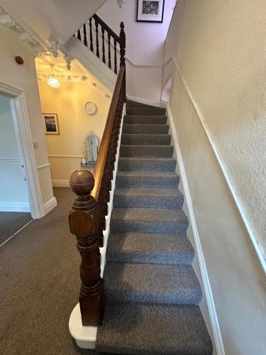 a staircase in a house with blue carpet at 21 Trinity Avenue in Llandudno