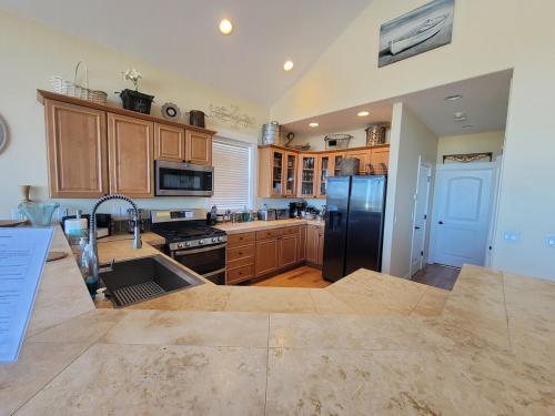 a kitchen with wooden cabinets and a stainless steel refrigerator at BelleVueVilla in Tillamook