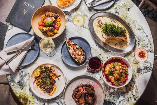 a table with many plates of food on it at Harbour Rocks by Ode Hotels in Sydney