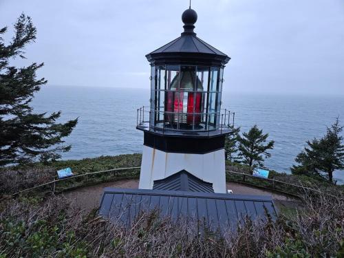 a lighthouse sitting on top of a hill next to the ocean at BelleVueVilla in Tillamook
