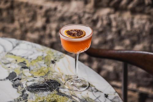 a drink in a wine glass sitting on a table at Harbour Rocks by Ode Hotels in Sydney