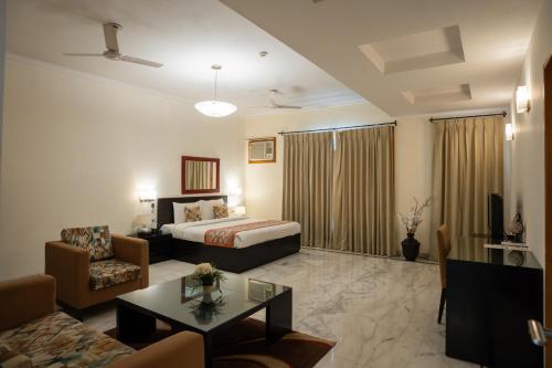 a hotel room with a bed and a living room at Ahuja Residency Cyber City I in Gurgaon