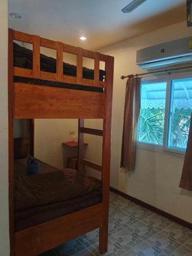 a bedroom with two bunk beds and a window at Ratatouille Guesthouse Koh Phangan in Thongsala