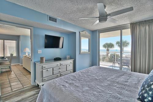 a bedroom with a bed and a flat screen tv at Oceanfront Crescent Shores Unit 106-Sleep12-4 bedrooms-6 beds-3 bathrooms in North Myrtle Beach
