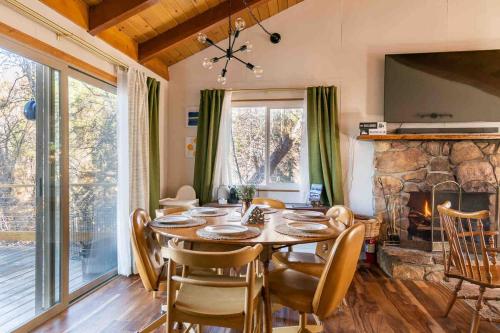 ein Esszimmer mit Tisch und Kamin in der Unterkunft New Yena Cabin in Moonridge in Big Bear Lake