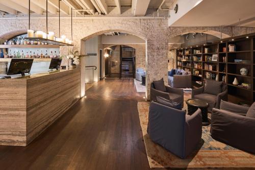 a lobby with chairs and a bar in a building at Harbour Rocks by Ode Hotels in Sydney