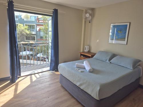 a bedroom with a bed and a large window at Boardrider Backpackers and Budget Motel in Sydney