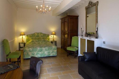 a bedroom with a bed and a couch and a mirror at Château de Fleurville & Spa in Fleurville