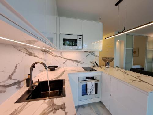 a kitchen with marble counter tops and a sink at La Croisette Côté Lac in Créteil