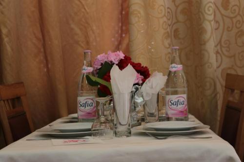 a table with two bottles of soda and flowers on it at Hotel Saint Georges Tunis in Tunis
