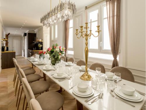 une grande salle à manger avec une longue table et des chaises dans l'établissement Merveil Signature Suite Hoche - Eiffel Tower view, à Paris