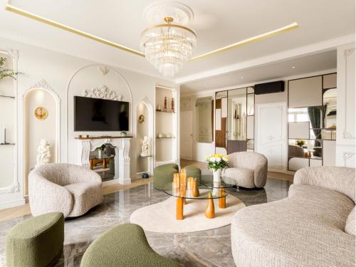 un salon avec un canapé, des chaises et une télévision dans l'établissement Merveil Signature Suite Hoche - Eiffel Tower view, à Paris