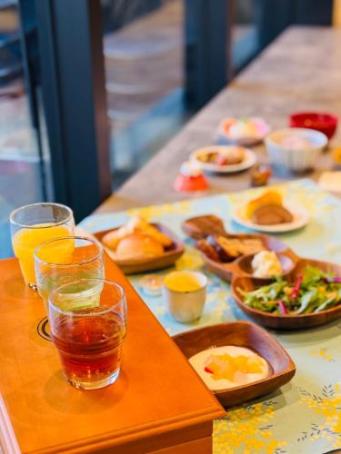 a table with plates of food and glasses of juice at Shizutetsu Hotel Prezio Kyoto Karasumaoike in Kyoto
