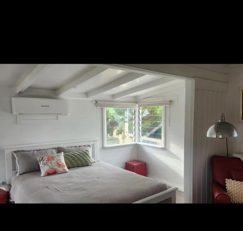 a bedroom with a large bed with a window at Cottage on the Burnett, Mundubbera in Mundubbera