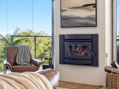 a living room with a fireplace and a chair at A La Plage - Ocean View Luxury - Family Friendly in Gnarabup