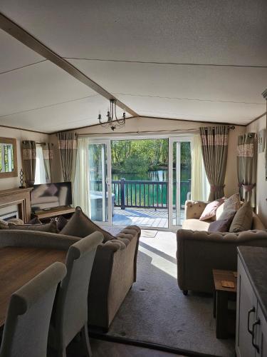 a living room with couches and a sliding glass door at Still Waters Luxury Retreat with Hot Tub -Tattershall Lakes in Tattershall