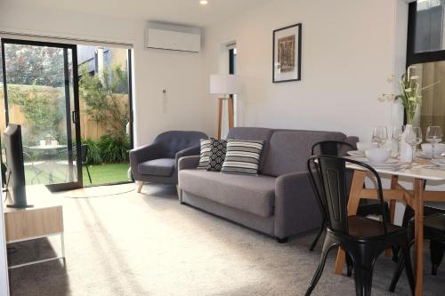 a living room with a couch and a table at Modern CBD, Walk to Te Pae, Across from Casino, FREE Parking in Christchurch