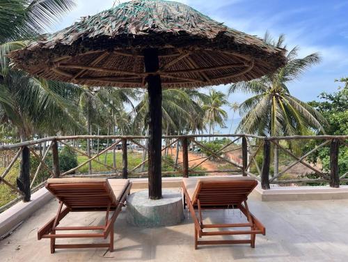 two chairs and an umbrella on a patio at Red Sands Mui Ne in Phan Thiet