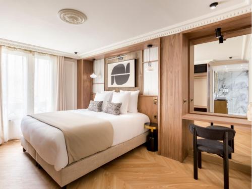 une chambre d'hôtel avec un lit et une chaise dans l'établissement Merveil - Signature Suite - Opera - Bateliere, à Paris