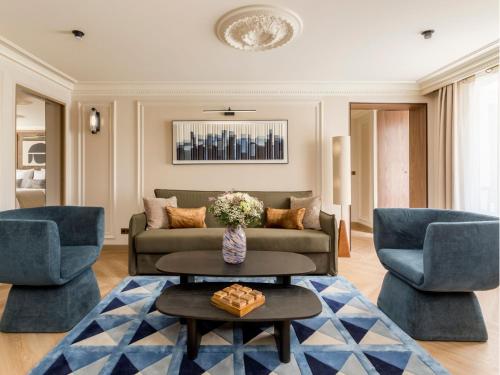 un salon avec un canapé et deux chaises dans l'établissement Merveil - Signature Suite - Opera - Bateliere, à Paris