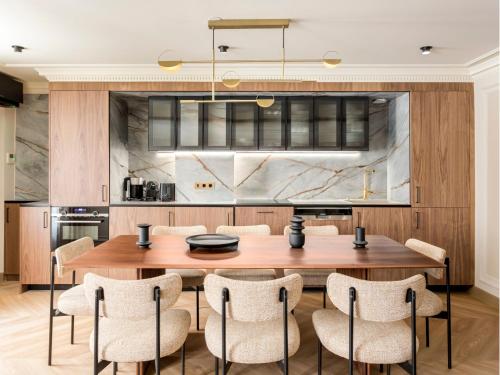 une cuisine avec une table et des chaises en bois dans l'établissement Merveil - Signature Suite - Opera - Bateliere, à Paris
