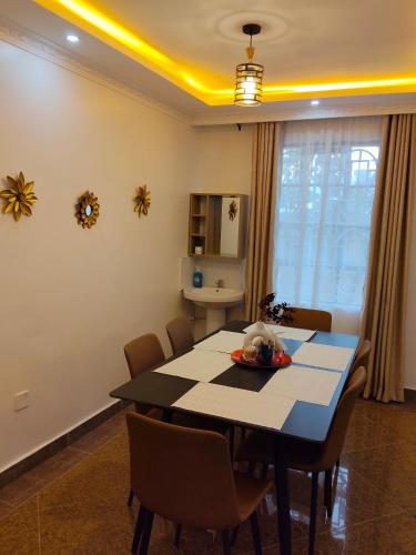 Un comedor con mesa y sillas en Rembeka Furnished 3BR Chui, en Munyu