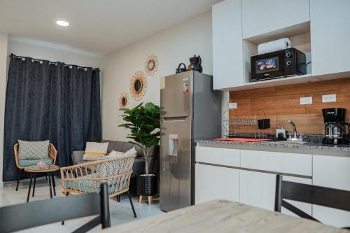 a kitchen and living room with a refrigerator and a table at Modern house, 5 minutes from El Salvador Airport in Astoria
