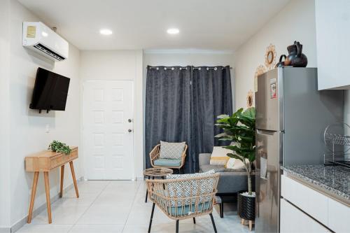 a kitchen and living room with a refrigerator and a couch at Modern house, 5 minutes from El Salvador Airport in Astoria