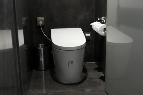 a bathroom with a toilet and a trash can at The Westin Xi'an in Xi'an