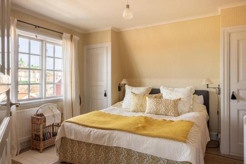 a bedroom with a large bed with a yellow blanket at The Pilot House, Sandhamn, Stockholm Archipelago in Sandhamn