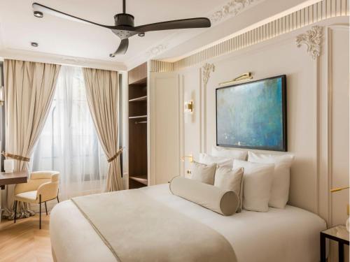 une chambre avec un grand lit blanc avec un ventilateur de plafond dans l'établissement Merveil - Signature Suite -Tour Eiffel- Grenelle I, à Paris