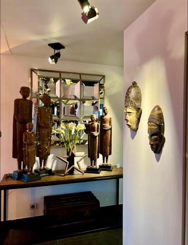 une pièce avec des statues et un miroir sur un mur dans l'établissement Chez les Stephs, à Magny-le-Hongre
