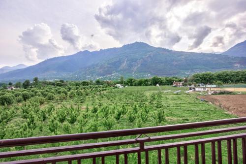 a view of a field with mountains in the background at Mountain Chalet By Vivaan in Shamshi