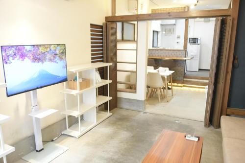 a living room with a flat screen tv and a table at Asakusa Sky House in Tokyo