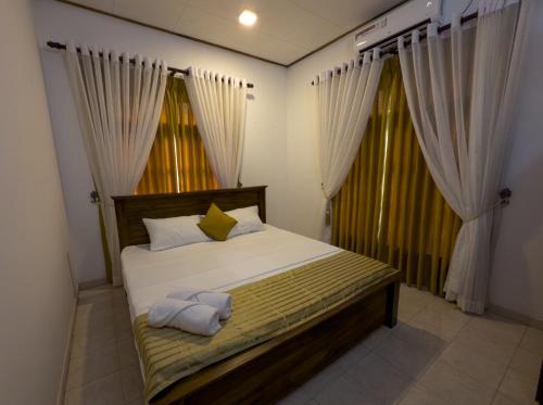 a bedroom with a bed with two towels on it at Aloe Serene in Negombo