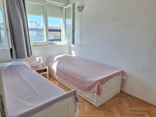Un dormitorio con dos camas y una ventana. en Apartment Matilda, en Split