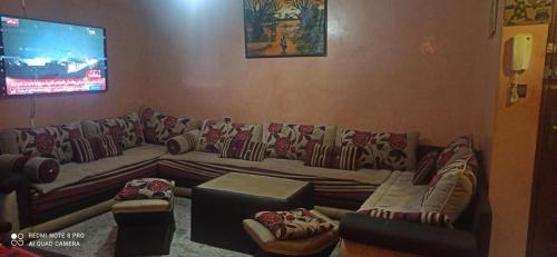 a living room with a couch and a tv at Hébergement Majd in Casablanca