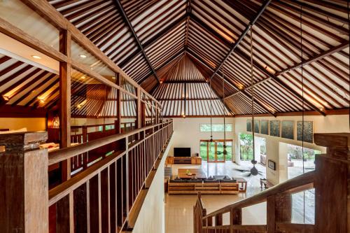 an open living room with a large wooden ceiling at Kelapa Villas in Gili Trawangan