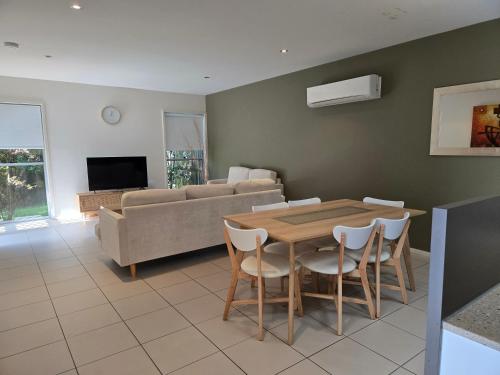 a living room with a table and a couch at Quarterdecks Retreat in Hervey Bay